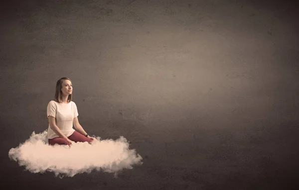 Woman sitting on a cloud with plain bakcground — Stock Photo, Image