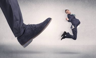 Küçük iş adamı tarafından büyük ayakkabı tekme