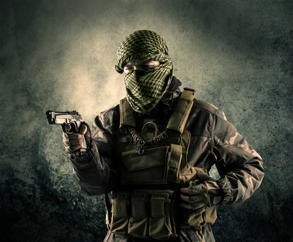 Portret van een zwaarbewapende gemaskerde soldaat met grungy achtergrond — Stockfoto