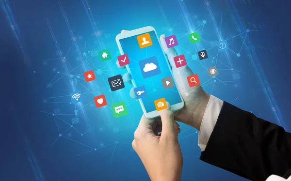 Main utilisant un smartphone avec des icônes d'application — Photo