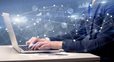 El laptop ile bağlantılı bir rapor ve grafikler çevresinde yazarak