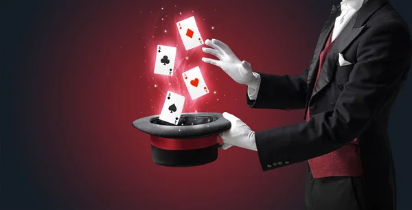 Magician making trick with wand and playing cards