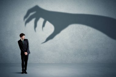 İş kişi büyük canavar pençe gölge kavramı korkuyor