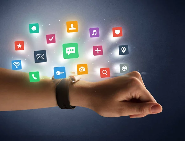 Vrouwelijke hand dragen smartwatch met app pictogrammen — Stockfoto