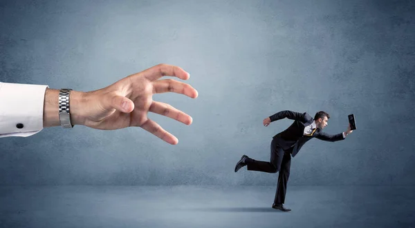 Businessman running from hand — Stock Photo, Image