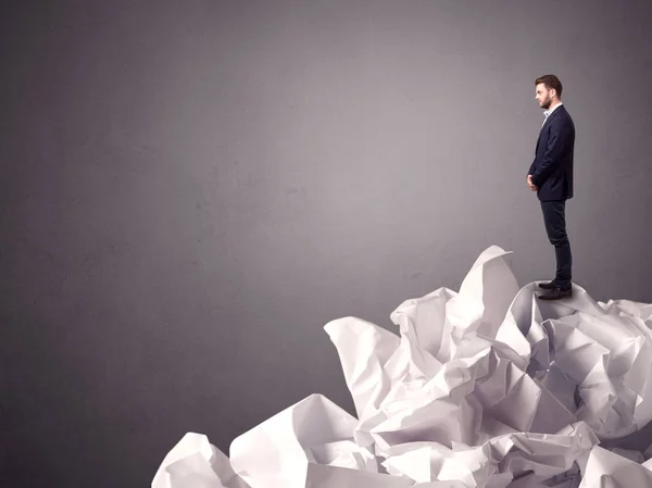 Businessman standing on crumpled paper — Stock Photo, Image