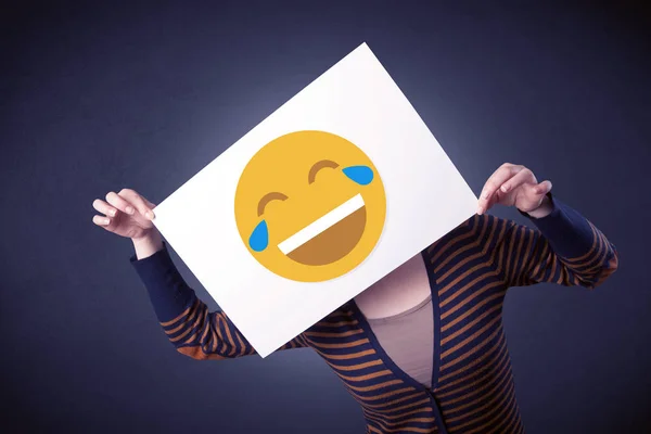 Mujer sosteniendo papel con emoticono risueño — Foto de Stock