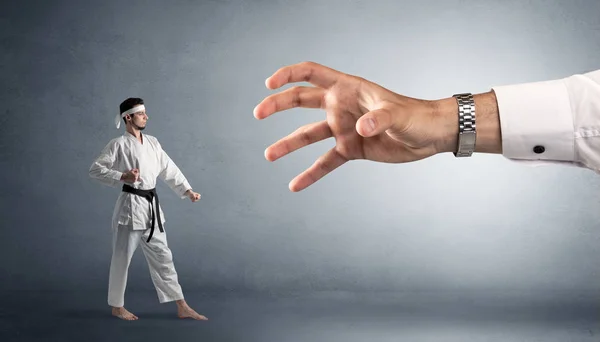Gran mano la captura de hombre pequeño karate —  Fotos de Stock
