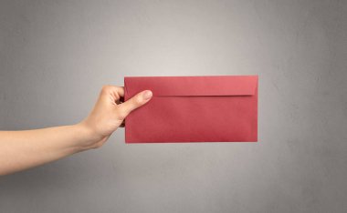 Zarf boş duvar arka plan ile tutan el