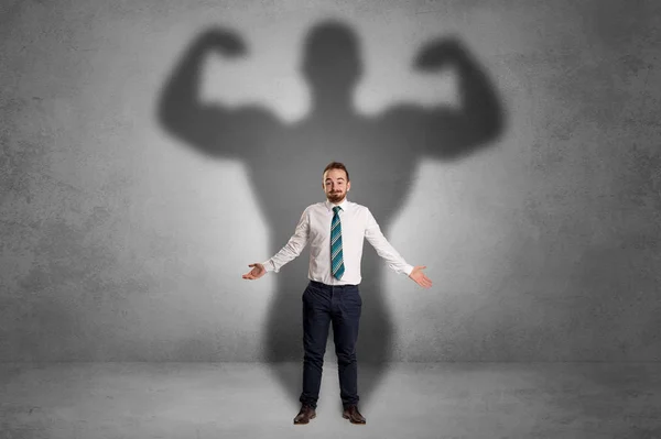 Businessman with muscular shade behind his back — Stock Photo, Image