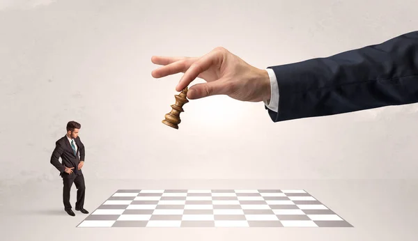 Lilla affärsman spelar schack med en stor hand koncept — Stockfoto