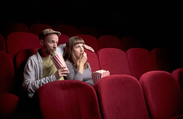 Young couple sitting at red movie theatre — Stock Photo, Image