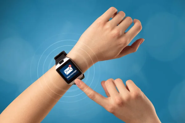 Mano con smartwatch e sfondo blu — Foto Stock