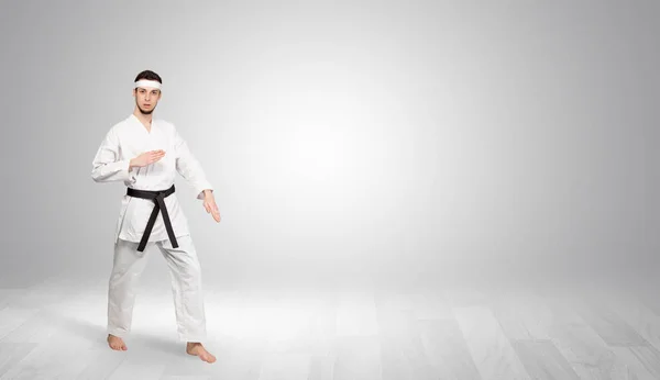 Karate-Trainer kämpft in einem leeren Raum — Stockfoto