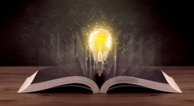 Harfler ve kitap üzerinde ampul 