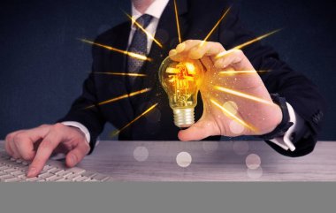 bir elektrik ampulü tutan iş kişi