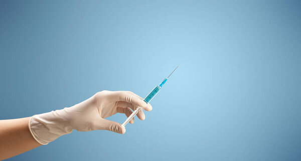 Женщина-врач держит шприц