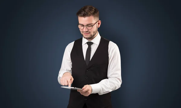 Businessman holding tablet with dark background — Stock Photo, Image