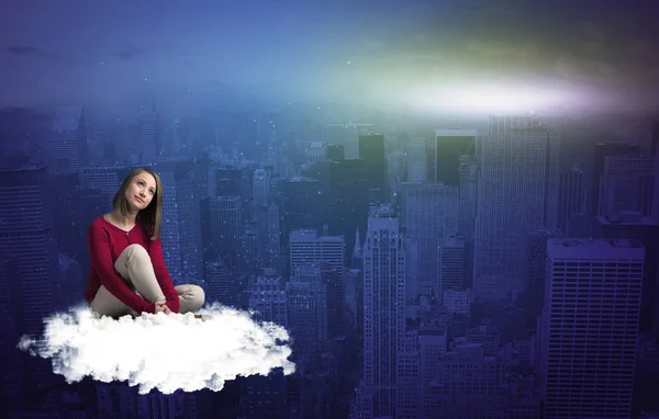 Жінка сидить на хмарі над містом — стокове фото