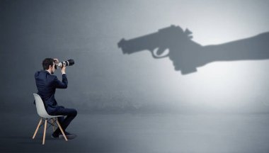 Kalmak ve bir silahlı gölge el için malzeme sunan iş adamı