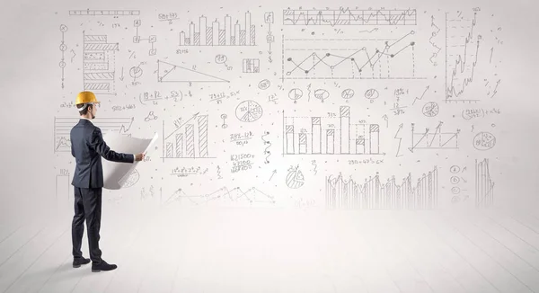 Mérnök gazdaság egy tervet, és állandó, grafikonok, diagramok és jelentések a háttérben — Stock Fotó