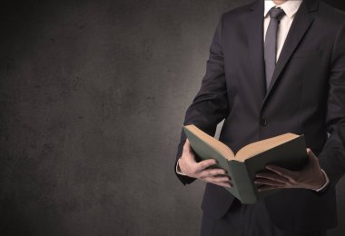 Elinde kitap tutan bir işadamı.