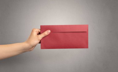 Zarf boş duvar arka plan ile tutan el