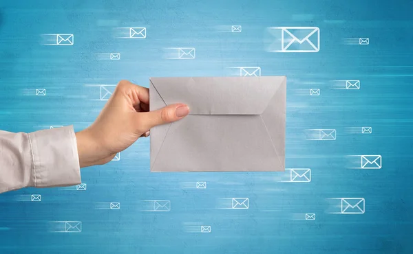 Hand holding envelope with message symbols around — Stock Photo, Image