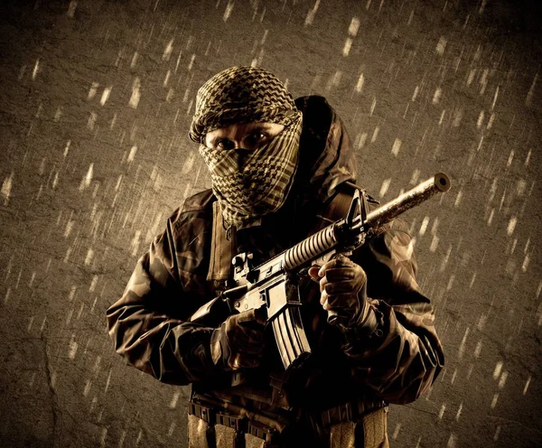 Perigoso soldado terrorista fortemente armado com máscara em fundo chuvoso grungy — Fotografia de Stock