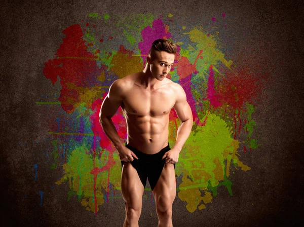 Strong guy with colorful paint wall and weight — Stock Image Strong guy with colorful paint wall and weight Royalty Free Stock Images