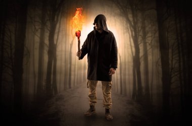 Adam flambeau onun el kavramında yanma ile karanlık ormandan gelen geliyor