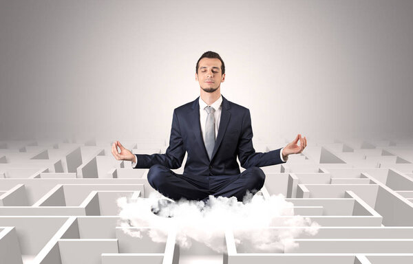 Businessman meditates on a cloud with maze concept