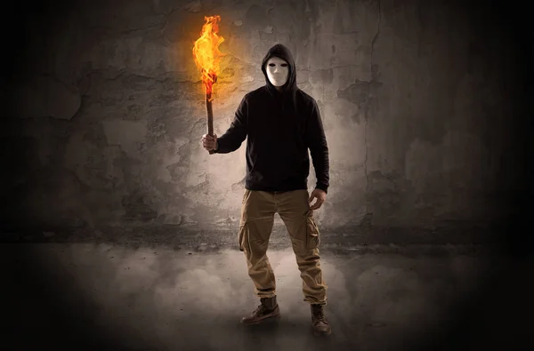 Wanderer mit brennender Fackel vor bröckelnder Mauer — Stockfoto