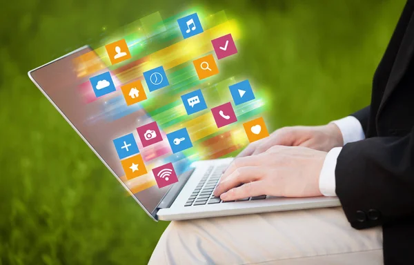 Hand laptop met kleurrijke toepassing pictogrammen en symbolen concept — Stockfoto