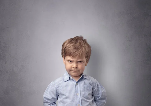 Bedårande liten pojke framför en tom vägg — Stockfoto