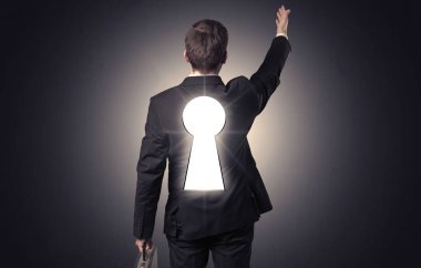 Sırtında siyah anahtar deliği ile ayakta adam