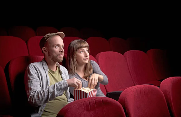 Young couple sitting at red movie theatre — Stock Photo, Image