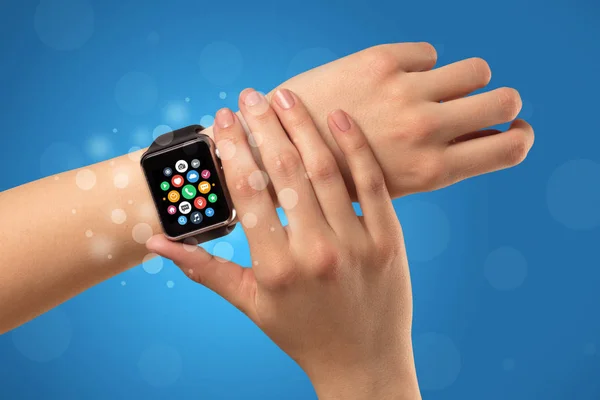 Mano femminile con smartwatch e icone app — Foto Stock