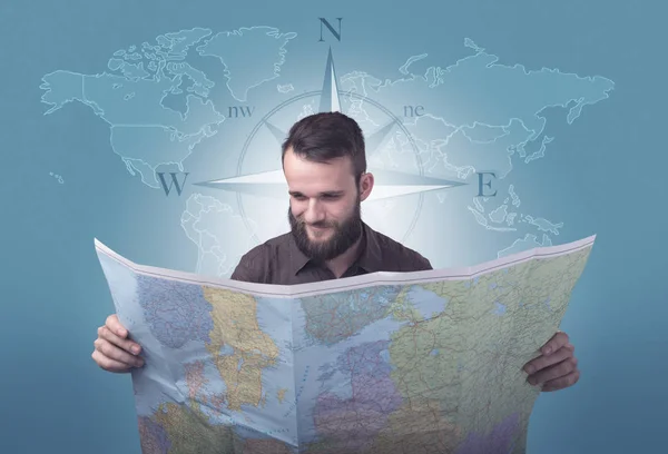 Genç adam tutarak harita — Stok fotoğraf