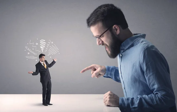 Young businessman fighting with miniature businessman — Stock Photo, Image