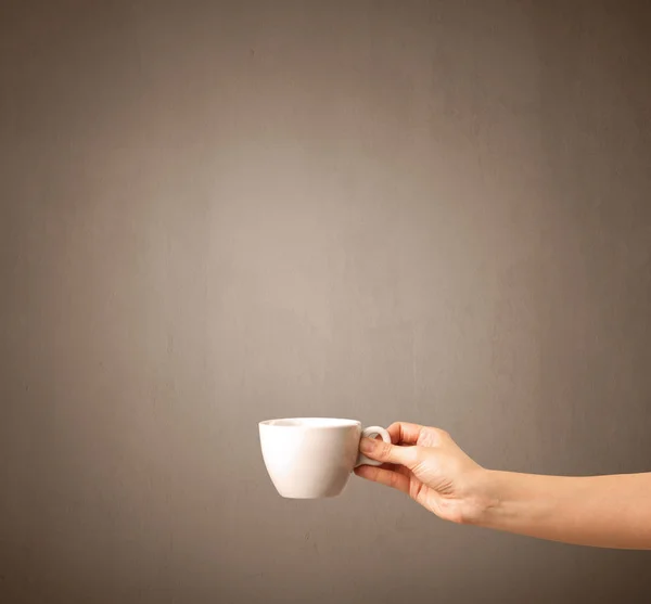 Vrouwelijke hand bedrijf koffie beker — Stockfoto