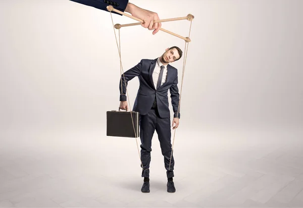 Puppet businessman leaded by a huge hand — Stock Photo, Image