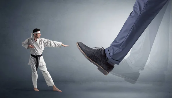 Pie grande pisando pequeño karate hombre — Foto de Stock