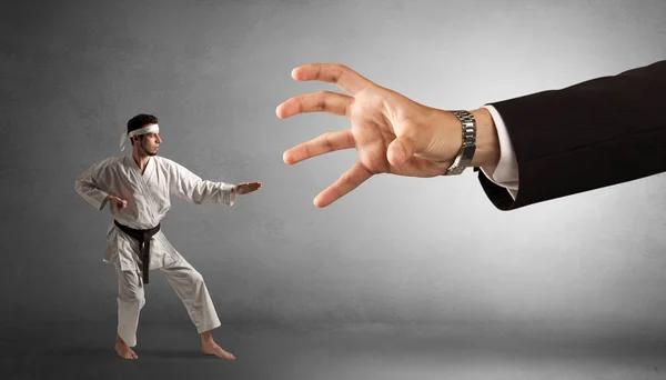 Stor hand fånga små karate man — Stockfoto