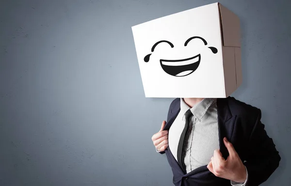 Hombre divertido sonriendo con cabeza de caja de cartón — Foto de Stock