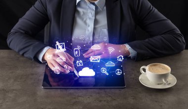 Yukarıdaki uygulama simgeleriyle tablet üzerinde çalışan iş kadın