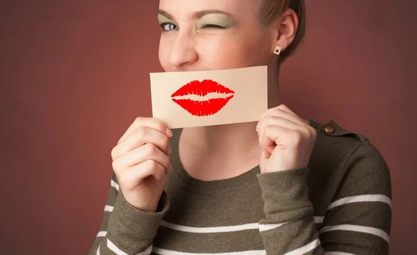 Persona sorridente con una carta davanti alla bocca — Foto Stock