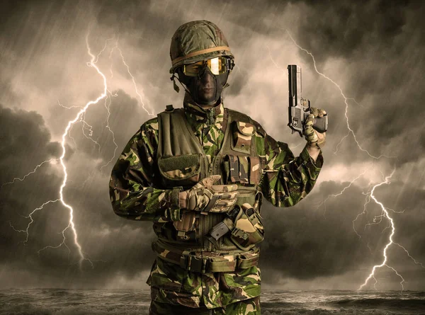 Soldado armado parado en un clima oscuro — Foto de Stock