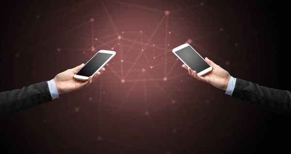 Close up of two hands holding smartphones — Stock Photo, Image