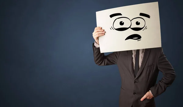 Person hält ein Papier mit lustigen Emoticons vor ihr Gesicht — Stockfoto